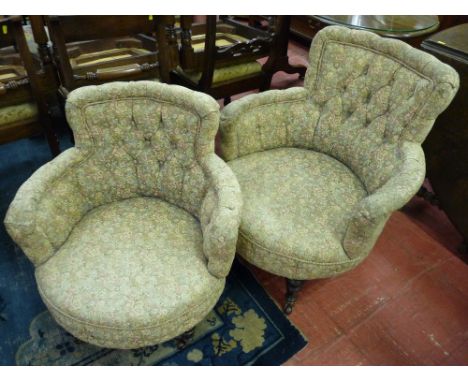 A PAIR OF EDWARDIAN BUTTON UPHOLSTERED SALON TUB CHAIRS, circular seated with floral fabric on turned front supports with bra