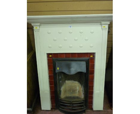 AN EDWARDIAN CAST IRON BEDROOM FIREPLACE AND SURROUND TOP MANTEL SHELF with lower bead and heart decoration, inset glazed red