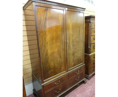 AN EDWARDIAN MAHOGANY COMBINATION WARDROBE with a blind fret cornice over twin opening doors, opening to reveal hanging shelf