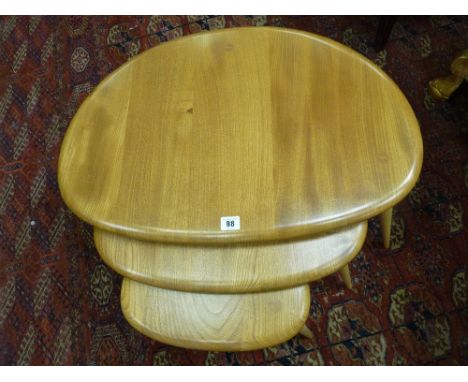 AN ERCOL LIGHT ELM NEST OF THREE PEBBLE TABLES, 40.5 cms high, 65 cms wide the largest