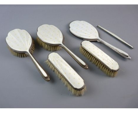 A HALLMARKED SILVER AND GUILLOCHE ENAMEL MIRROR AND BRUSH SET, comprising hand mirror, four brushes and a comb holder, pearl 