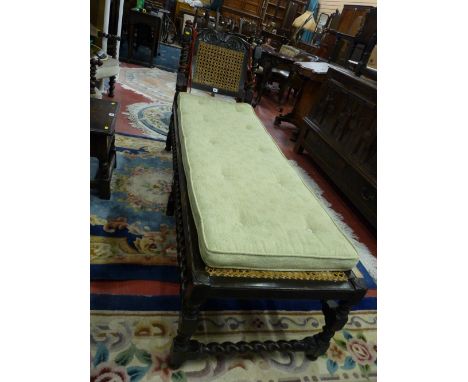 A CAROLEAN STYLE CARVED OAK DAY BED with floral crested top rail, barley twist and block supports, bergere style canework and