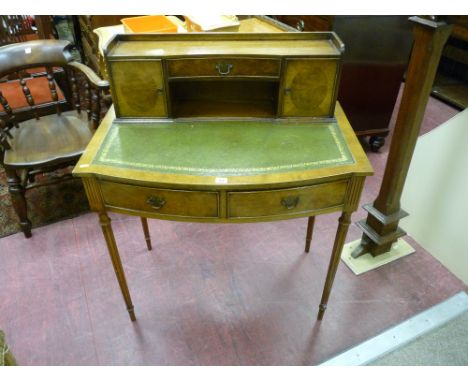 A REPRODUCTION WALNUT LADY'S WRITING DESK, the top shelf section with concave drawer and lower shelf, flanked by cupboard doo