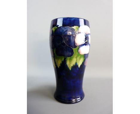 A MOORCROFT PANSY CYLINDRICAL VASE, cobalt blue ground, 24 cms high, 11.5 cms diameter with waisted lower body, marked to the