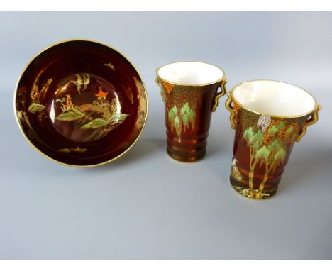 THREE PIECES OF CARLTONWARE ROUGE ROYALE to include a pair of stork pattern ribbed vases with gilt handles and a 15.5 cms dia