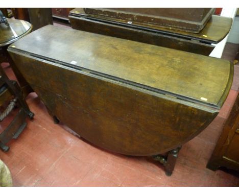 AN ANTIQUE OAK OVAL TOPPED GATE LEG DINING TABLE on barley twist and block supports with twist stretchers, 74 cms high, 135 c