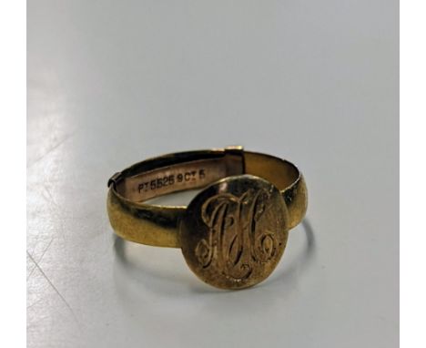 A 22ct gold signet ring, engraved with the initials AH, having a 9ct gold attached size adjuster to the inside of the ring, t