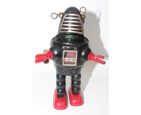 A KO Toys of Japan tinplate and clockwork planet Robbie the robot, comprising of a black body with red hands and red feet com