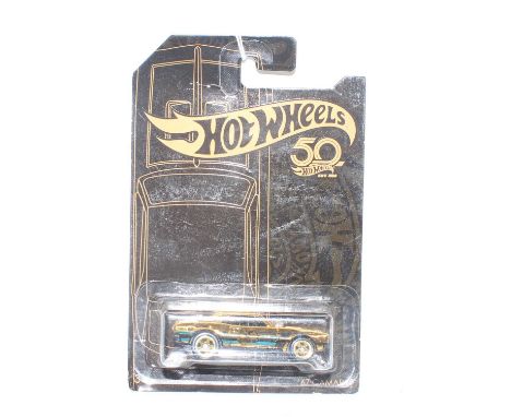 A Hot Wheels Mattel 50th Anniversary gold plated model of a 1967 Camaro, housed on the original backing card