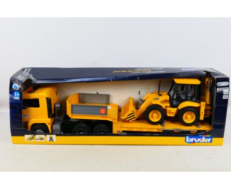 Bruder - A boxed plastic 1:16 scale MAN TGA truck with low loader trailer and JCB 4CX Backhoe Loader. The set shows some slig