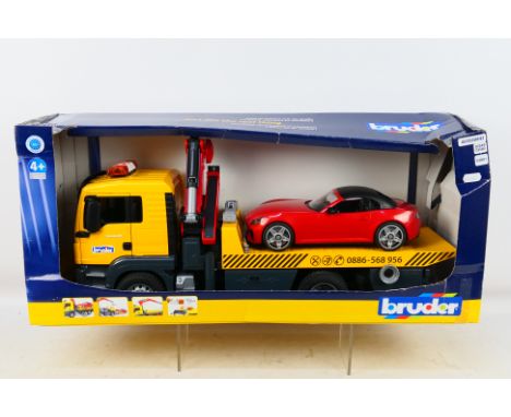 Bruder - A boxed plastic 1:16 scale MAN TGS Tow truck with Light & Sound Module plus 'Bruder' Roadster. The set show some dus