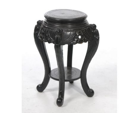 A Chinese carved hardwood jardinière stand
The black lacquered stand with carved scroll circular top, extending to four scrol