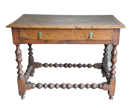 An 18th Century and later oak side table
The rectangular moulded top above a single frieze drawer with two brass droplet hand