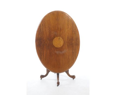 A Victorian walnut oval loo table
The quarter veneered oval top centred with a circular inlaid panel, raised up on a ring tur