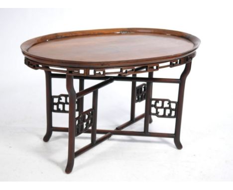 A Chinese huanghuali style occasional low table, late Qing/Republic Period 
The single plank oval top with everted rim, with 