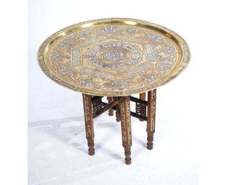 A Middle Eastern inscribed brass tray table, early 20th Century 
The large circular top, inscribed with Islamic text and scro