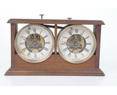 A 1920s Reliable Chess Timer, Hamburg American Clock Company, Wurttemberg 

The stained oak case housing twin glazed dials, w