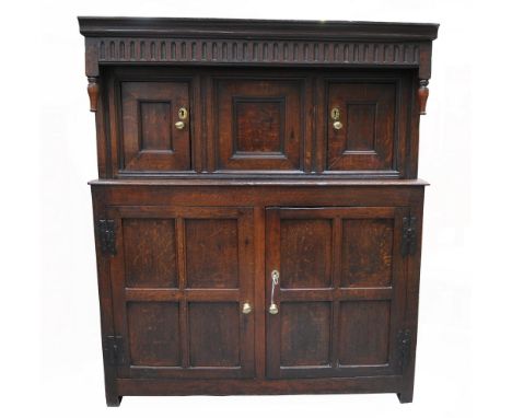 An impressive 17th century and later oak court cupboard
With a chiselled frieze above a central inverted panel, flanked by tw