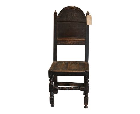 A 17th Century and later oak back stool
The arched panelled back above a plank seat on block and bobbin turned supports with 