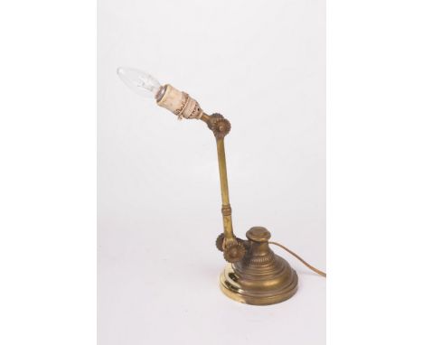 A brass adjustable desk lamp, circa 1910 
The domed and splayed stepped base, extending to an adjustable slender cylindrical 
