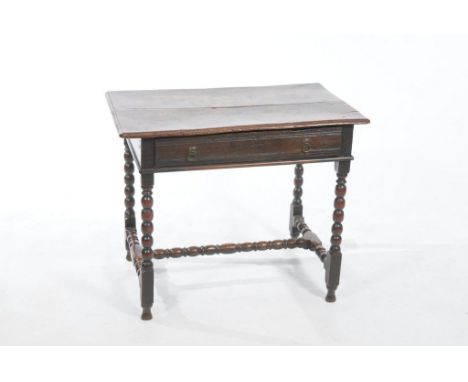 An 18th Century oak side table
The rectangular moulded top above a single frieze drawer with ring handles, raised on bobbin t