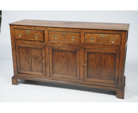 An 18th / 19th Century oak dresser base
The rectangular top above three frieze drawers each with brass droplet handles over t