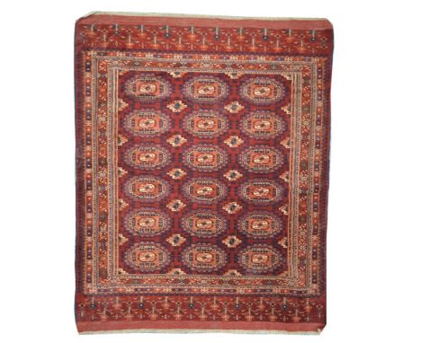 A Bokhara style rug
On a predominently ruby red ground, with light orange highlights, with a central repeating stepped medall
