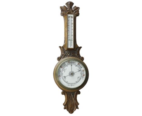 Oak aneroid barometer/thermometer, the 8" principal cream dial within a foliate carved case, 33" high 