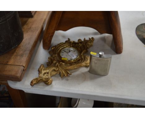 A wall clock; and a hip flask