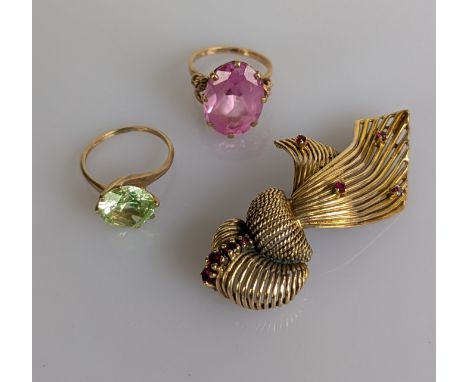 A yellow gold and ruby knot brooch, 60mm, unmarked but test for 9ct gold and two gem-set 9ct yellow gold dress rings, sizes M