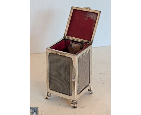 An Edwardian silver mounted playing card holder with hinged lid, lined leather-effect interior, bevelled glass walls on stepp