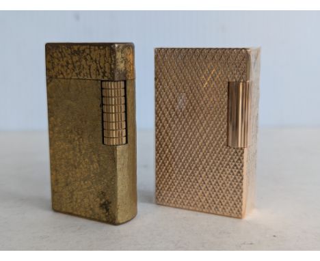 A vintage S. T. Dupont gold plated textured lighter in unopened plastic wrap, with original box, 58 x 13 x 35mm and a Dunhill