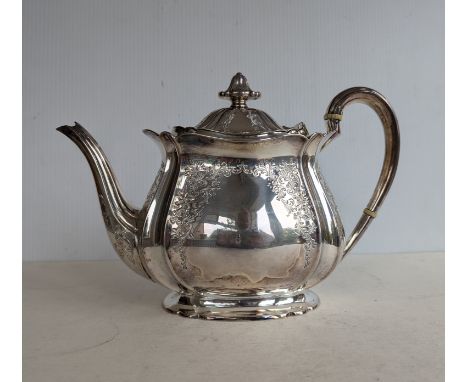 An Edwardian silver teapot of squat form with floral and foliate etched decoration on a raised base, hallmarked for Atkin Bro