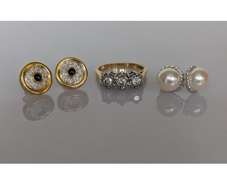 A pair of 18ct yellow gold sapphire and diamond earrings, stamped; a three-stone diamond ring on an 18ct yellow and white gol