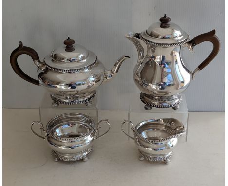 A George V silver four-piece matching tea and coffee service of squat form, gadrooned rims, fruitwood handles on fluted ball 