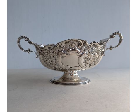 A late Victorian silver twin-handled oval basket with embossed rococo decoration on a raised foot, hallmarked for Henry Matth