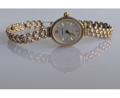 A ladies Accurist quartz dress watch with oval dial, baton markers on a 9ct gold case and fancy-link bracelet strap, hallmark