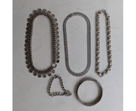 Three elaborately carved silver neck chains, a curb-link bracelet with heart locket and a silver bangle, 70mm internal diamet