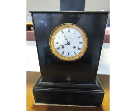 A Victorian black slate mantel clock with 8 day brass movement striking on a bell, the white enamel dial marked Roman numeral