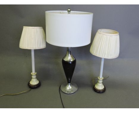 A contemporary table lamp, of ebonised baluster form with chrome mounts, together with two further lamps, (3)