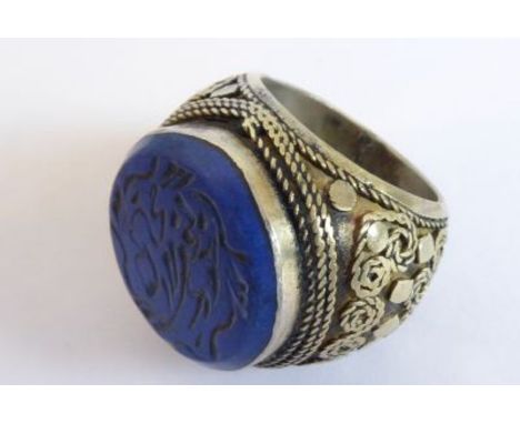 An unusual large Eastern (possibly Persian?) silver ring; the shank modelled with robe-style scrolling circular motifs and th