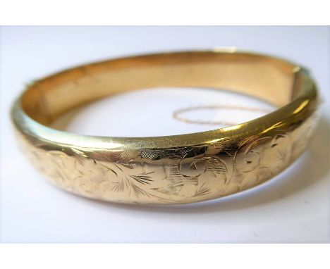 A 9-carat yellow-gold hollow bangle with safety chain (approx. 16.6g)