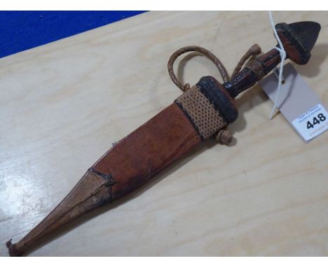 An early 20th century Eastern-style dagger within a leather scabbard (33cm)