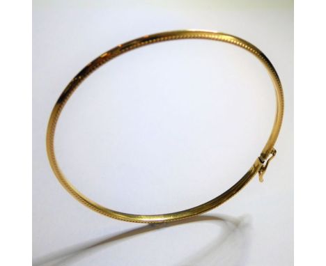 A 9-carat yellow-gold bangle with safety clip, internal diameter approx. 5.5cm, weight 3.1g