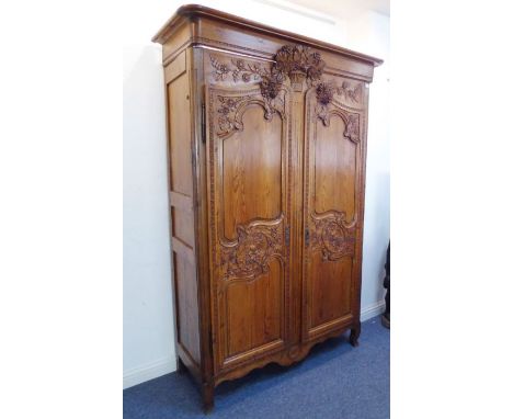 A fine early 19th century French pitch pine armoire of good colour and large proportions: the outset cornice above a centrall