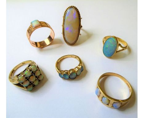Six opal-set rings including an oval opal hallmarked 18-carat yellow gold collet and bifurcated shank, size P and five rings 