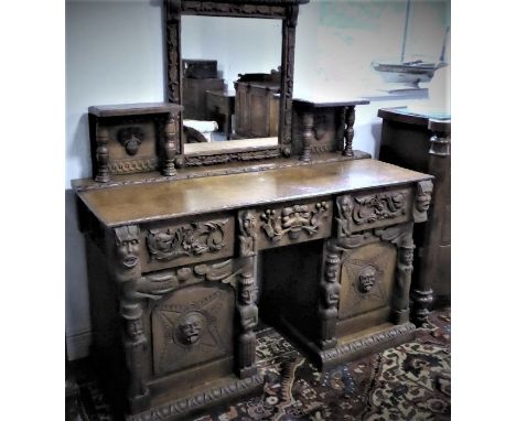 An unusual late 19th century colonial-style pedestal oak sideboard: the central mirror with a frame carved in high relief wit