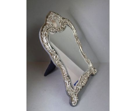 A late 19th century silver-mounted lady's easel-style dressing table mirror: elaborate and ornate Rococo-style frame decorate