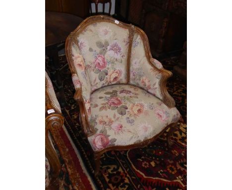 A late 19th century French carved walnut and floral tapestry upholstered tub chair; the show wood arms carved with acanthus t