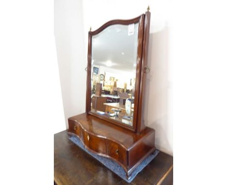 A late 18th century serpentine-fronted mahogany toilet mirror; the hand-bevelled mirror plate within moulded frame and two ve
